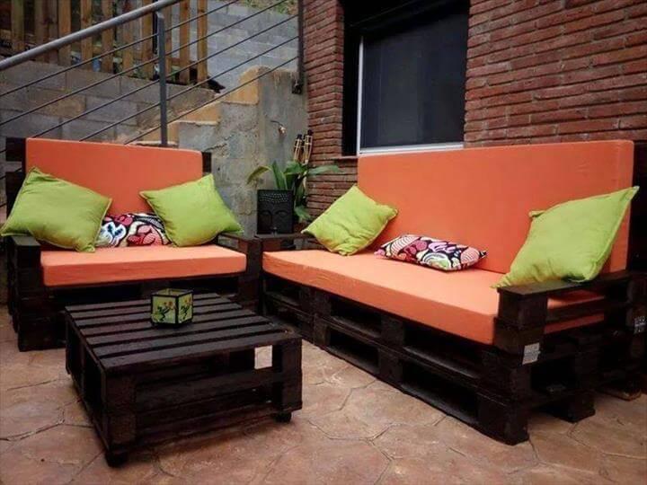 black stained pallet sofa with orange cushion