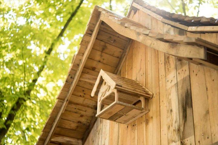 pallet cabin with birdhouse mounted on front wall